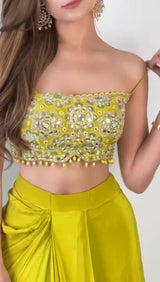 Closeup of intricate embroidery and mirror work on the blouse and shrug of the designer dhoti set.

